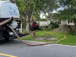 On-site septic pumping and maintenance services across the Houston area Septic service truck performing tank pumping with extended hose at a Houston property