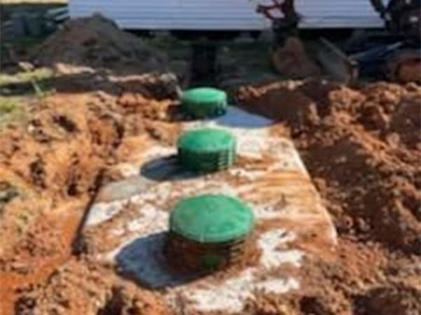 Heavy equipment digging trench for new septic tank installation in Southeast Texas Heavy equipment digging trench for new septic tank installation in Southeast Texas