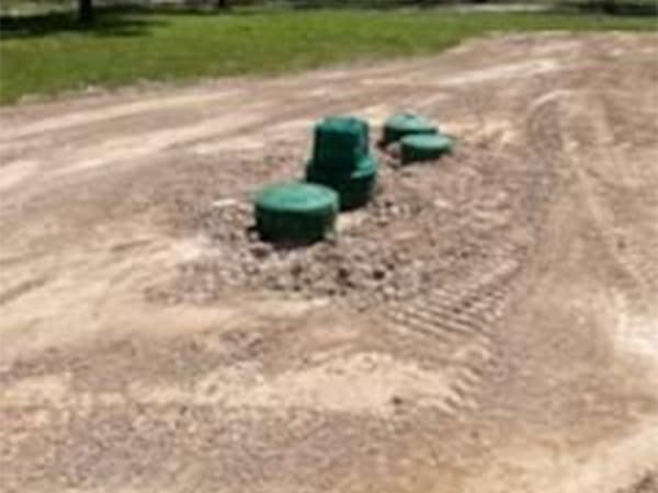 New concrete septic tank being lowered into prepared excavation site New concrete septic tank being lowered into prepared excavation site